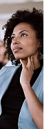 Woman with curly hair looks thoughtful in a blue blazer, indoor setting