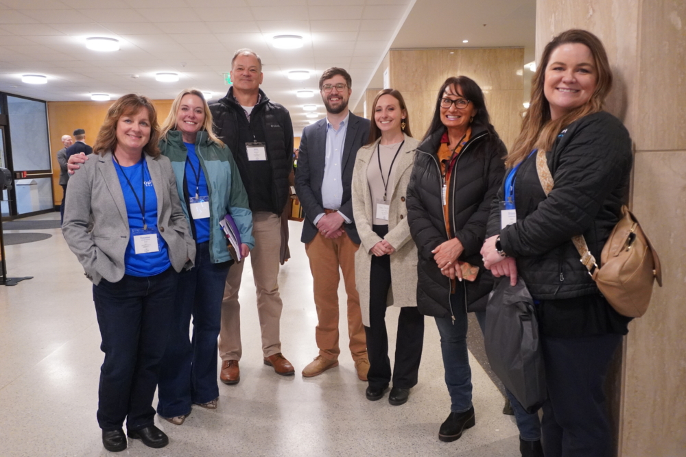 Group of smiling professionals at a conference in a modern lobby setting