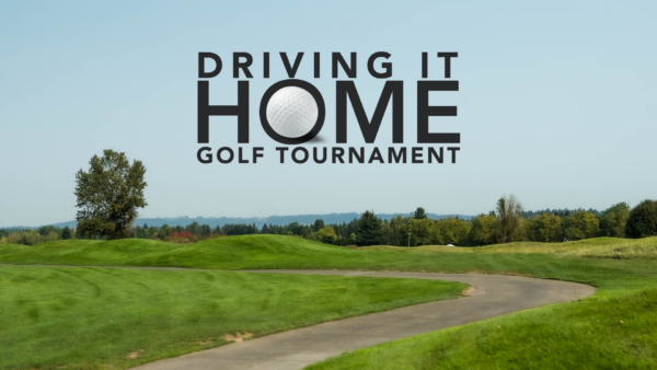 Driving It Home golf tournament banner on lush green course