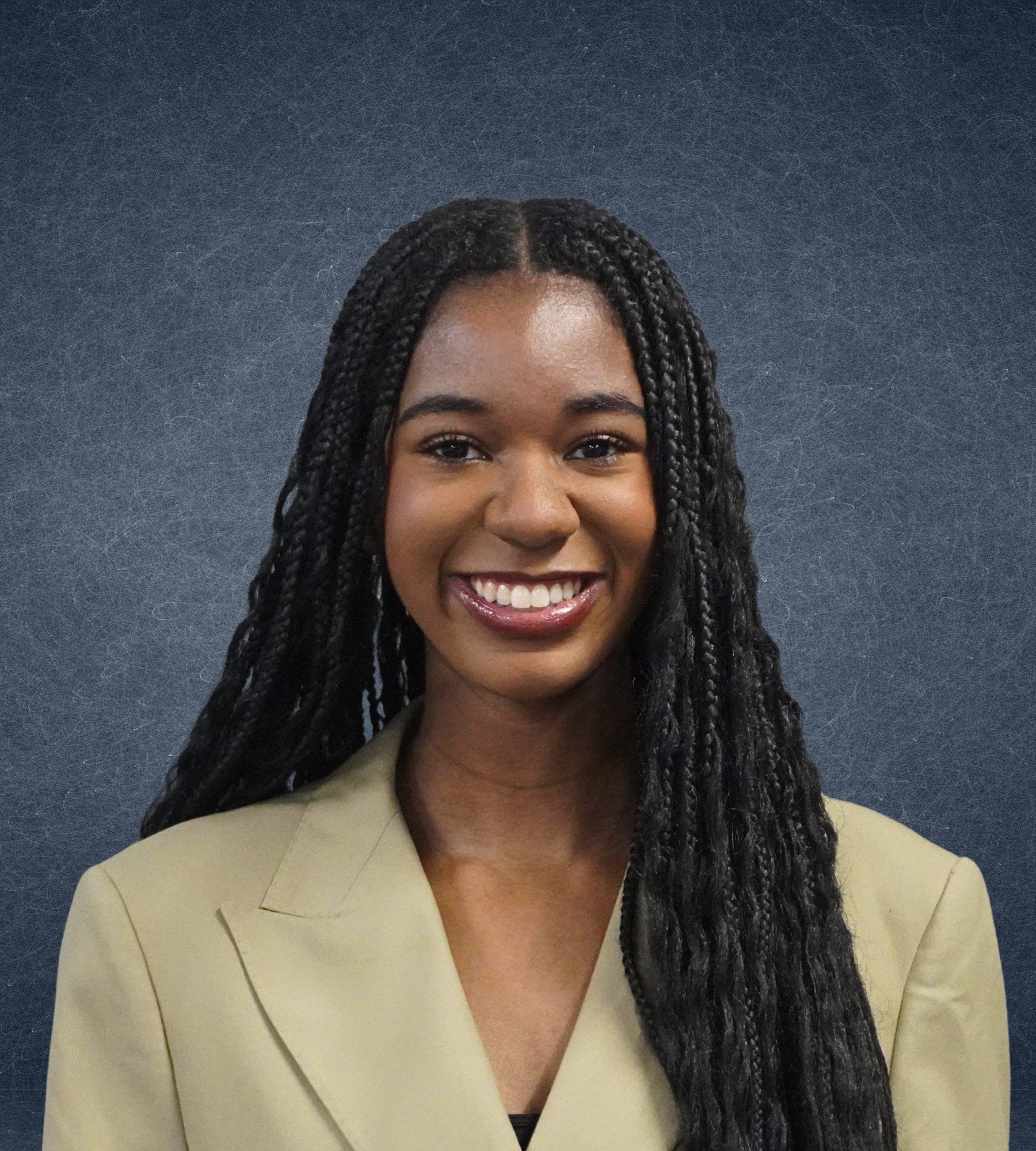 Smiling woman with long braids wearing a beige blazer against a dark textured background