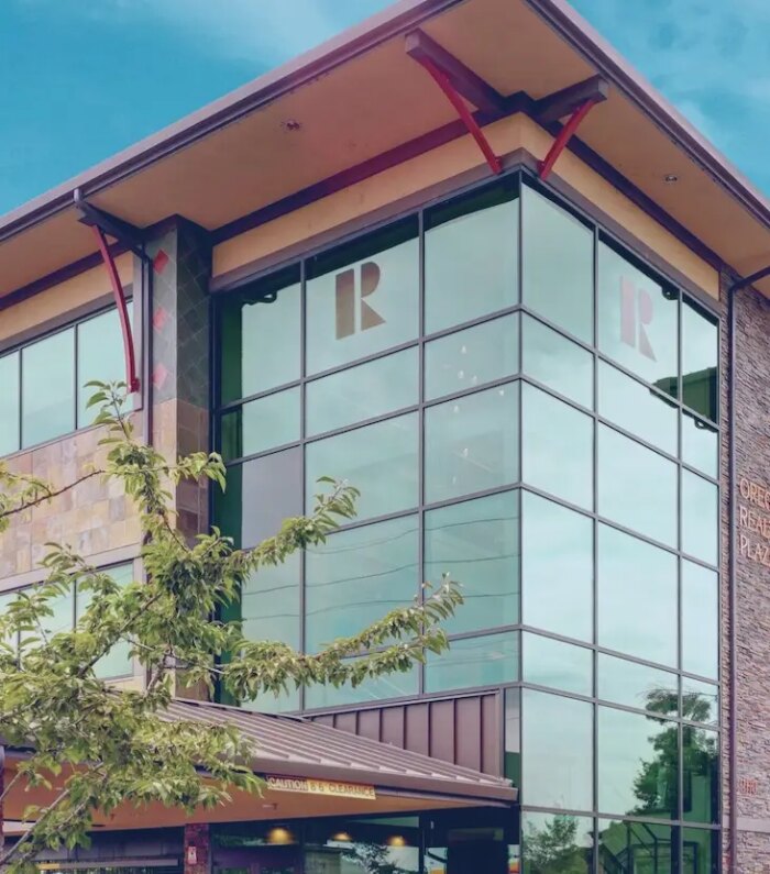 Modern commercial building with large glass windows against a blue sky background