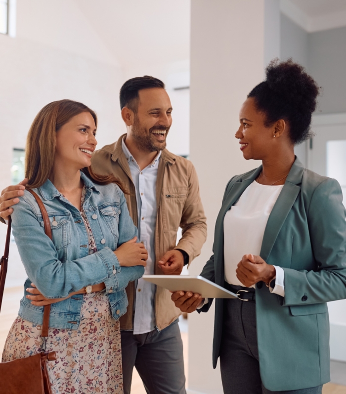 Real estate agent discussing property with a smiling couple